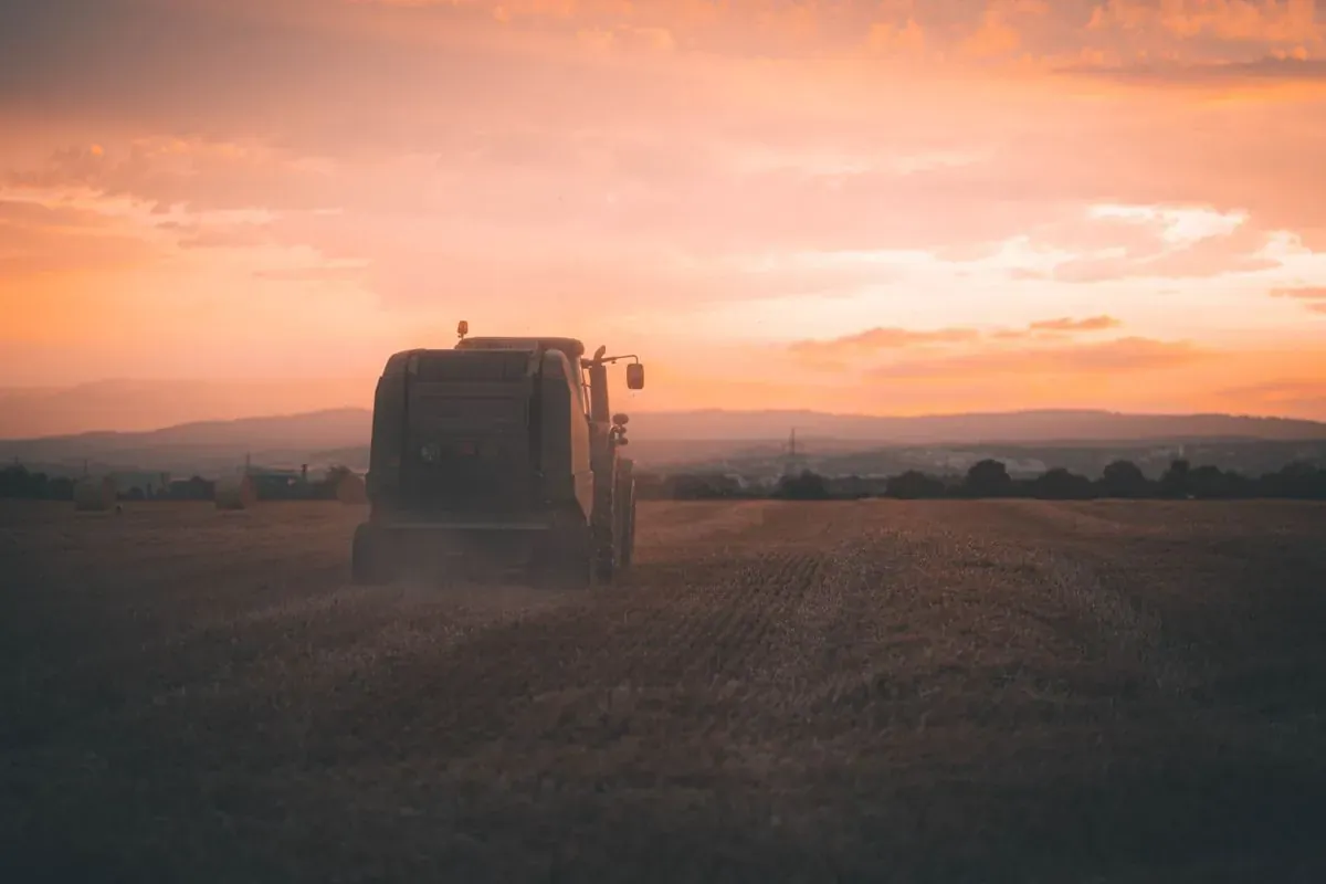 Trator em operação no campo ao entardecer